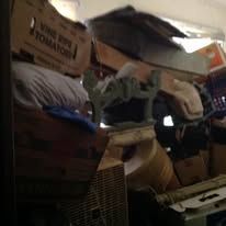 Messy storage room with various boxes and items.