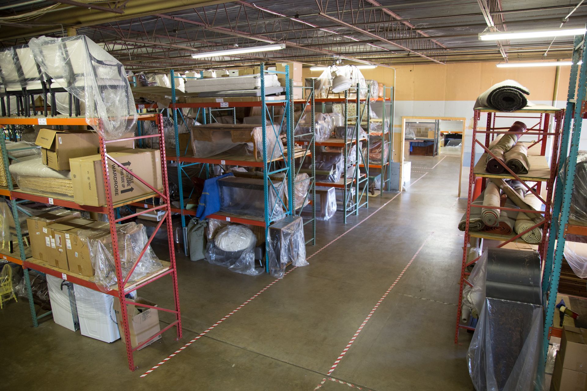 Warehouse with rows of metal shelving filled with packaged goods.