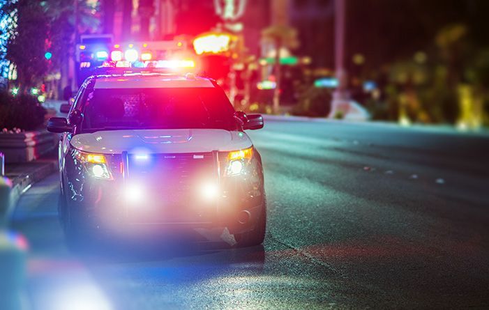 Police car with flashing lights pulling over a driver suspected of DUI.