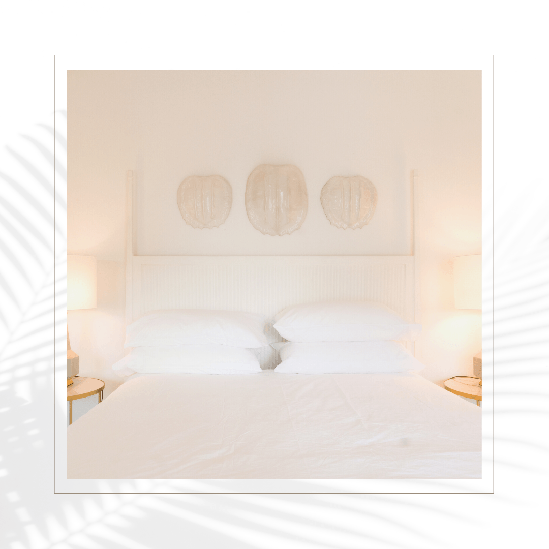 A bedroom with a bed and three lamps on the wall