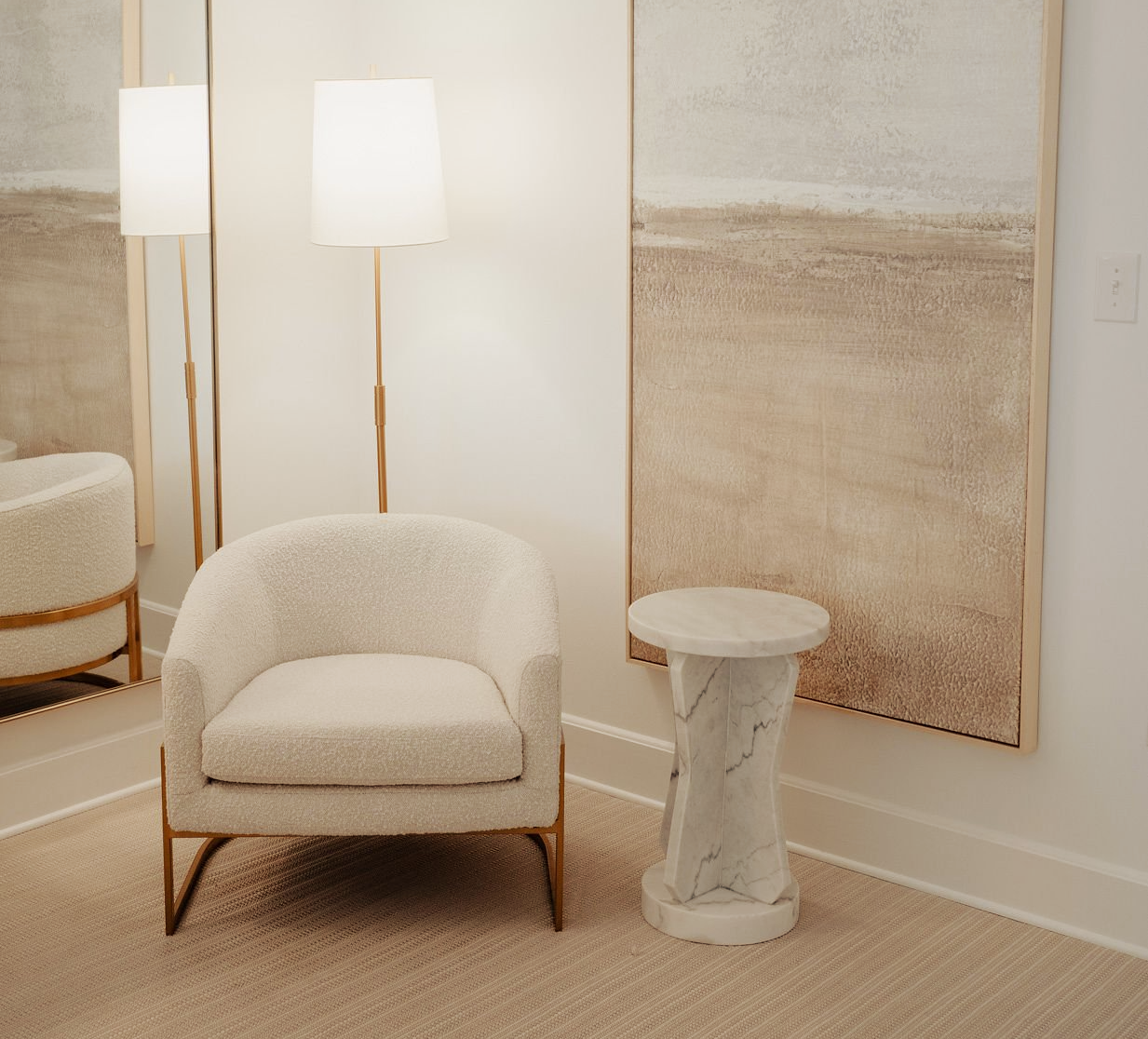 A chair and a table in a room with a painting on the wall