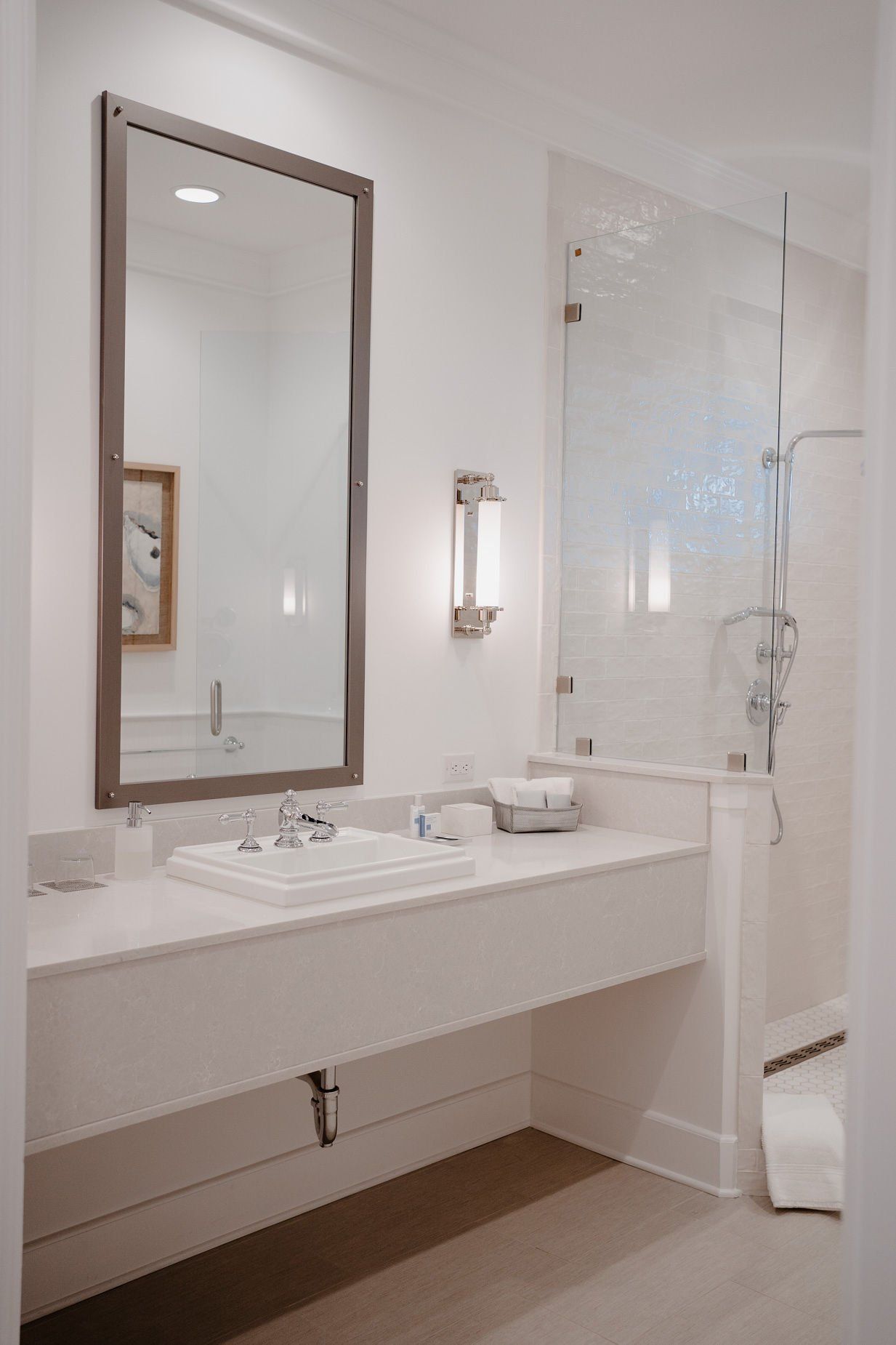A bathroom with a sink , mirror and shower in a hotel