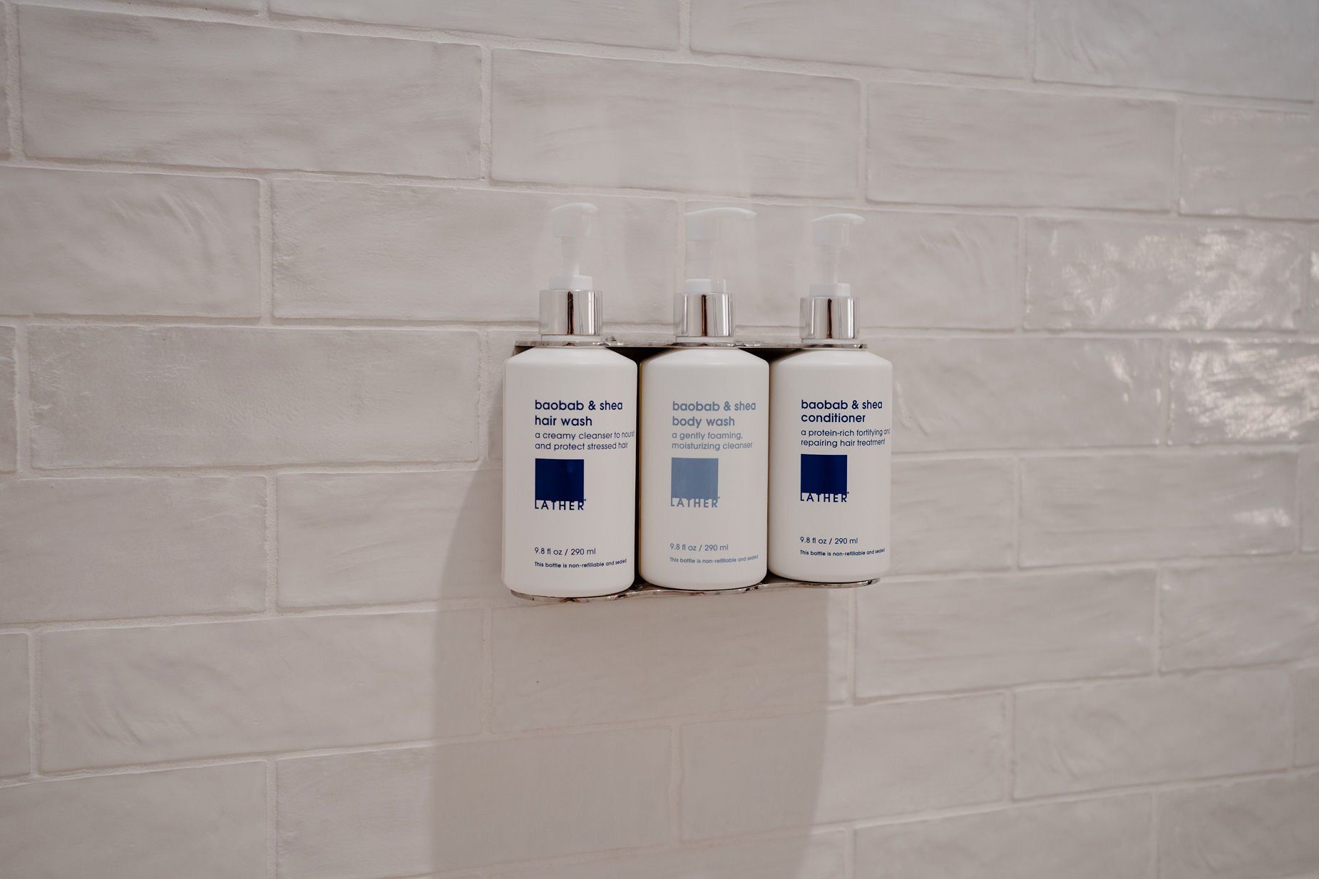 Three bottles of shampoo are hanging on a wall