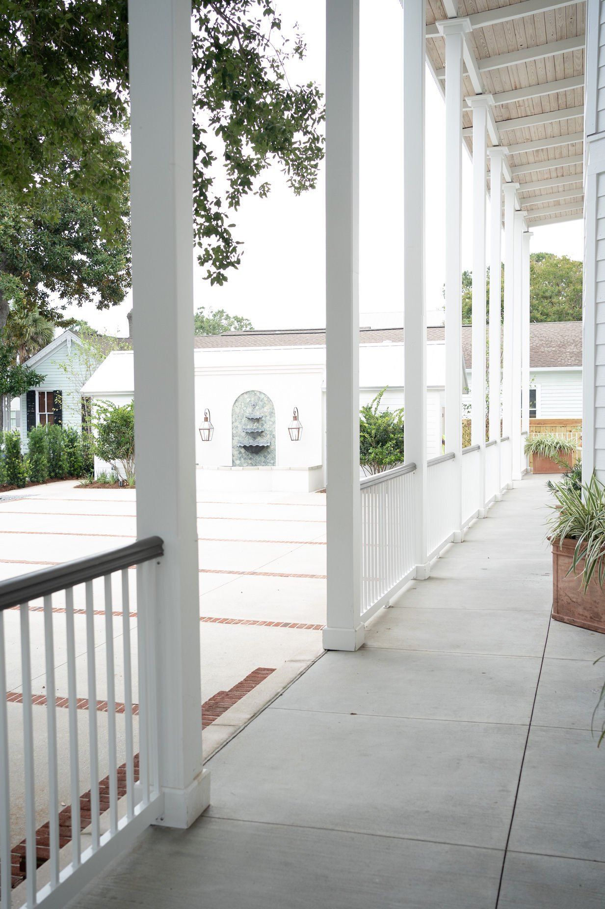 A long white porch with a fountain in the background