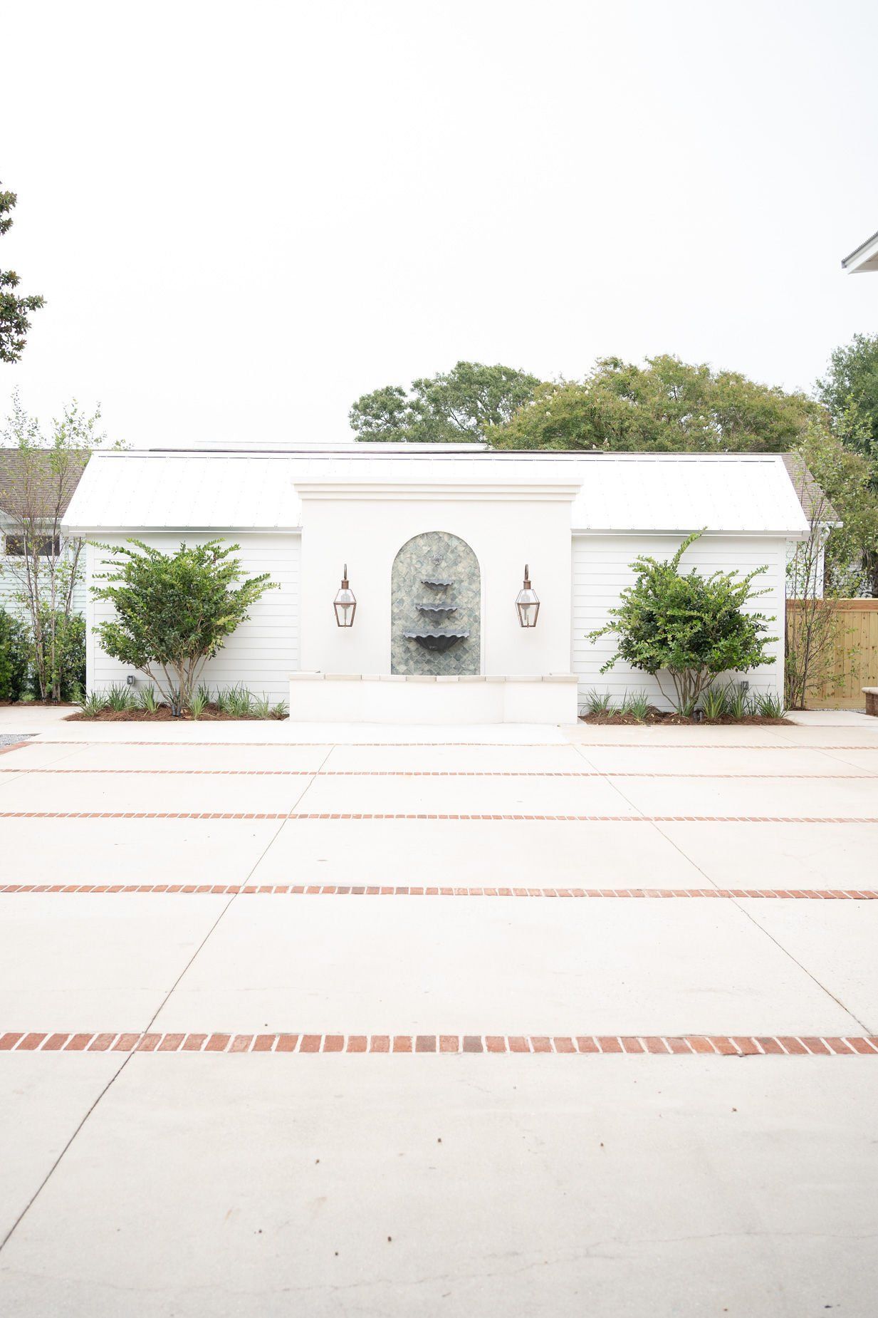 A courtyard with a fountain in back of it