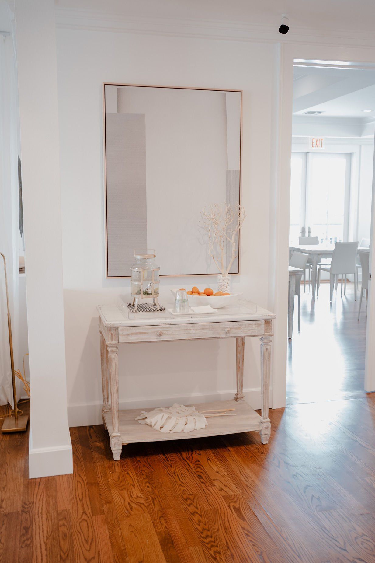 A hallway with a table and a mirror on the wall