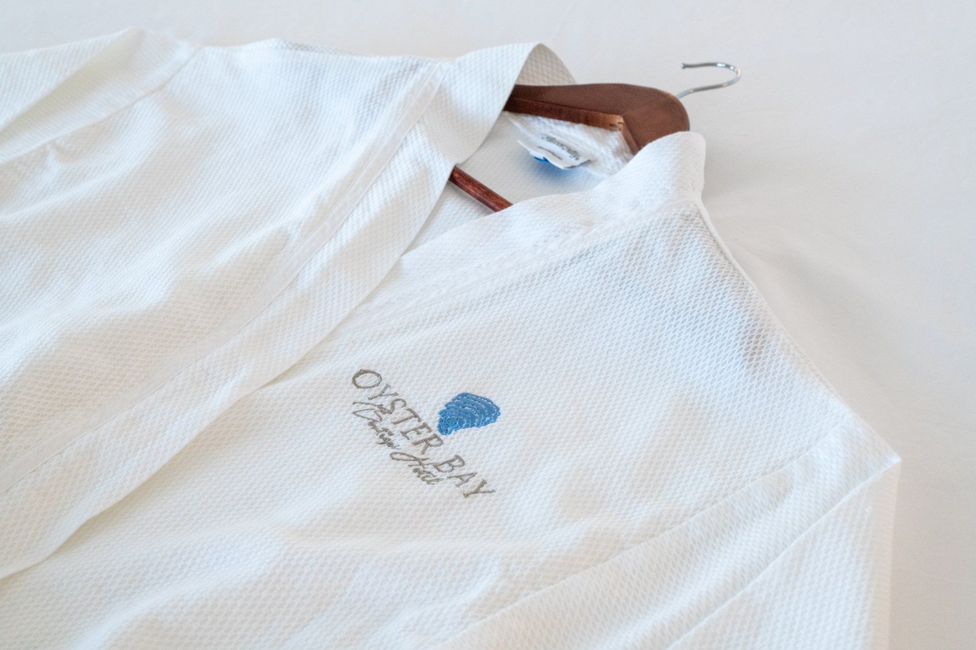 A white robe with the word oyster bay on it