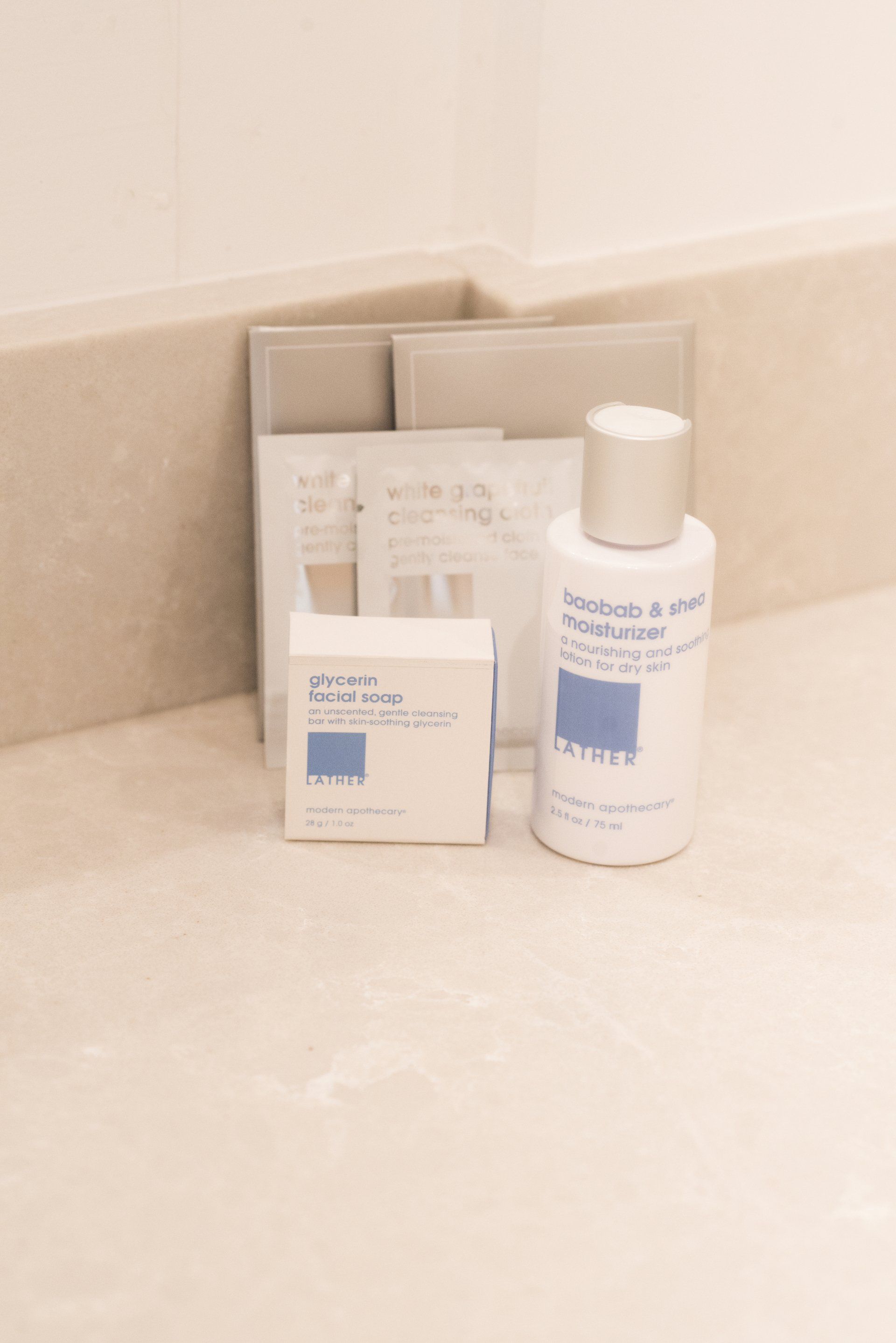 A bottle of lotion sits on a counter next to a bar of soap