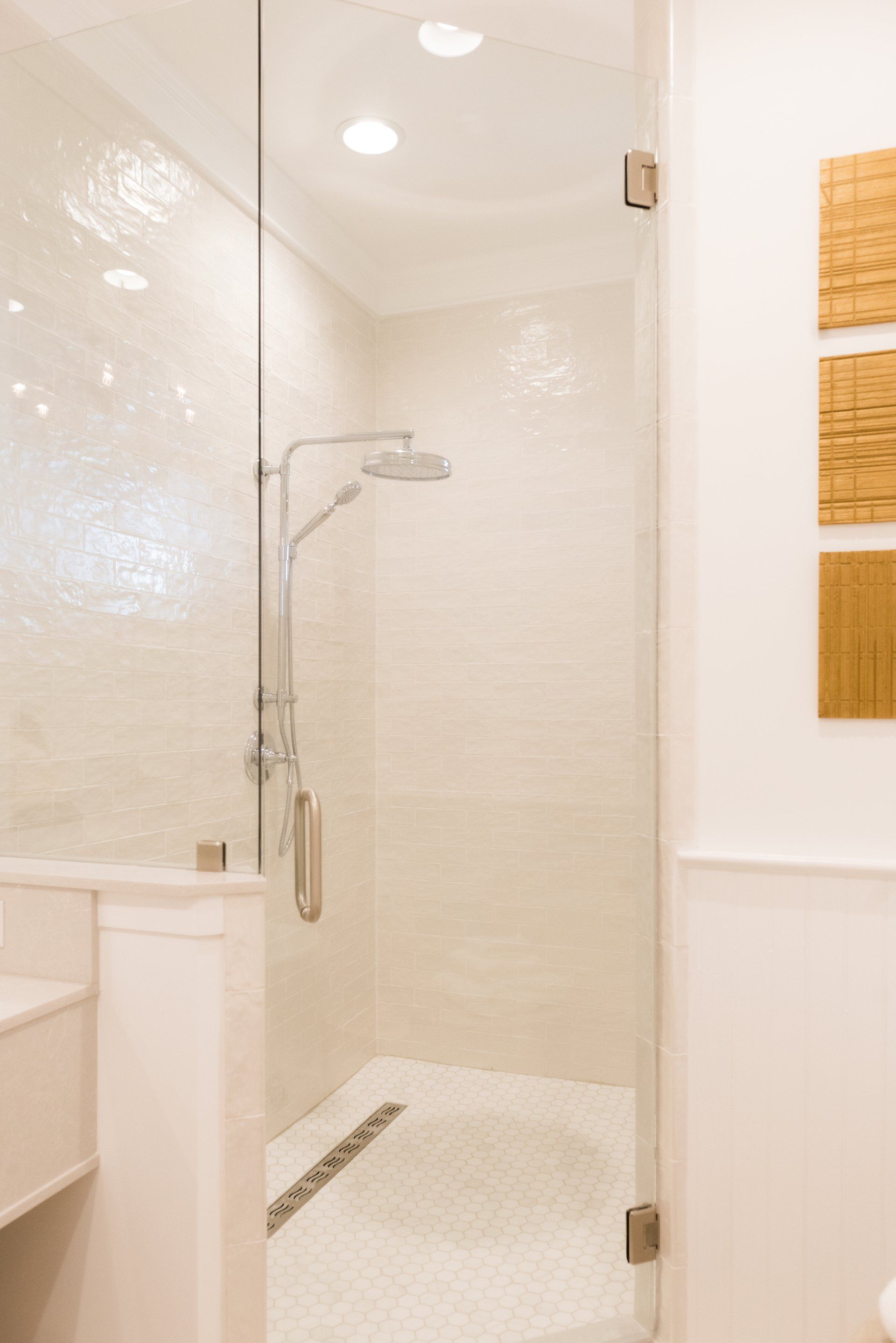 A bathroom with a walk in shower with a glass door