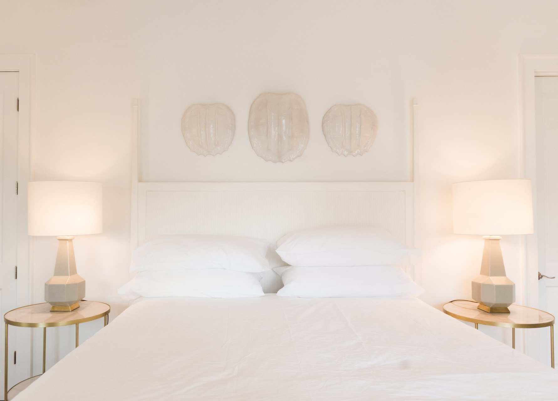 A bedroom with a bed and two lamps