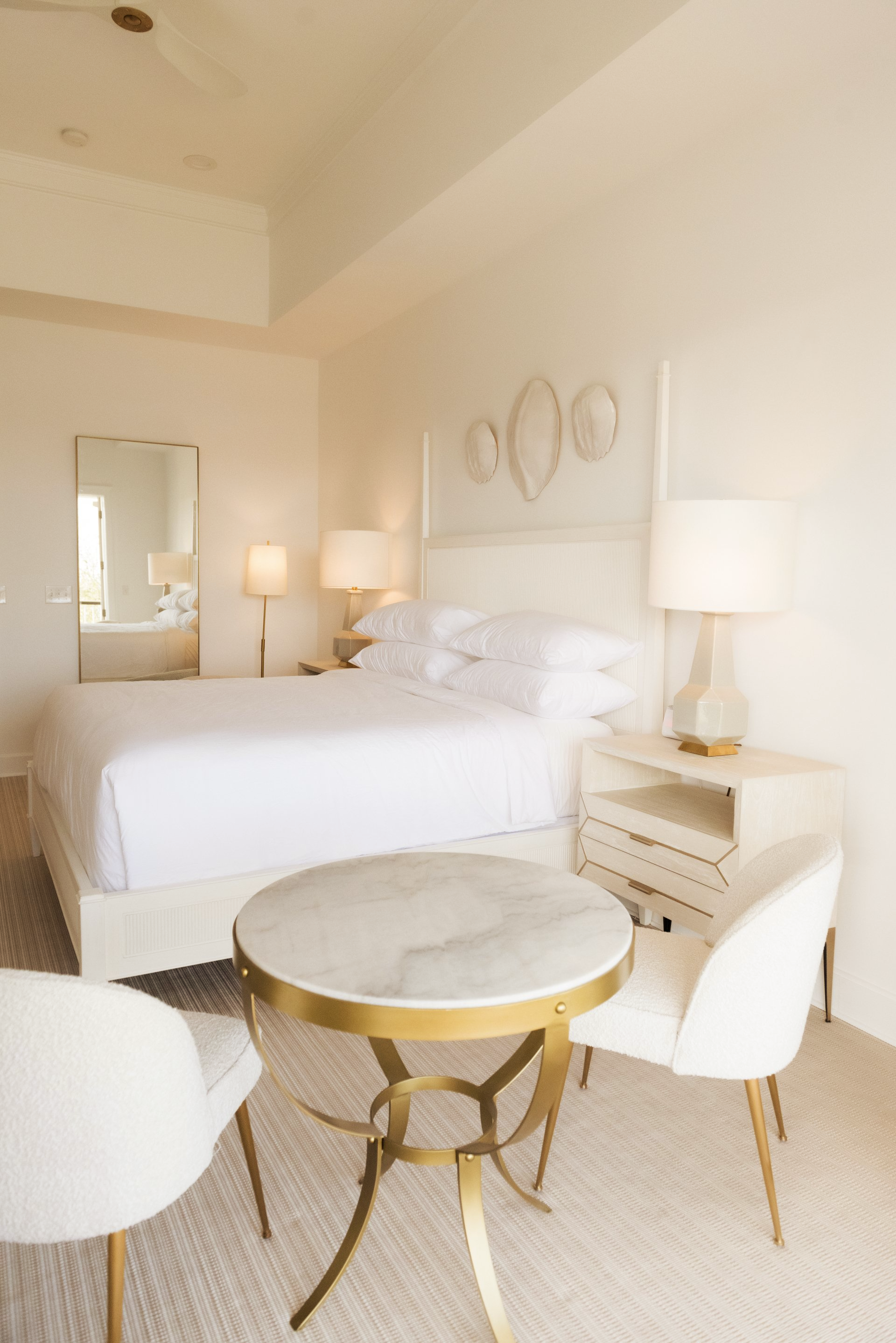 A bedroom with a king size bed a table and chairs