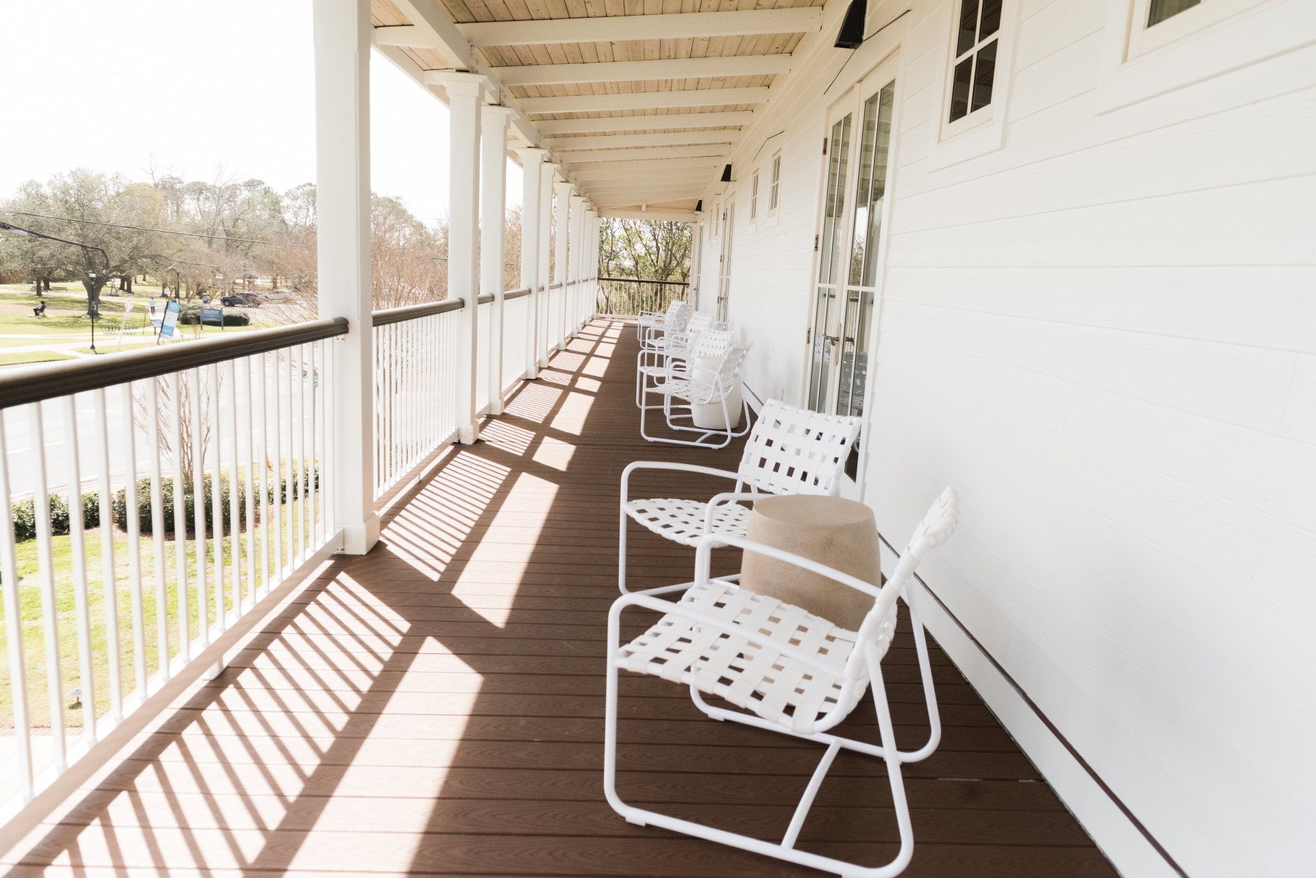 A white porch with chairs and a table