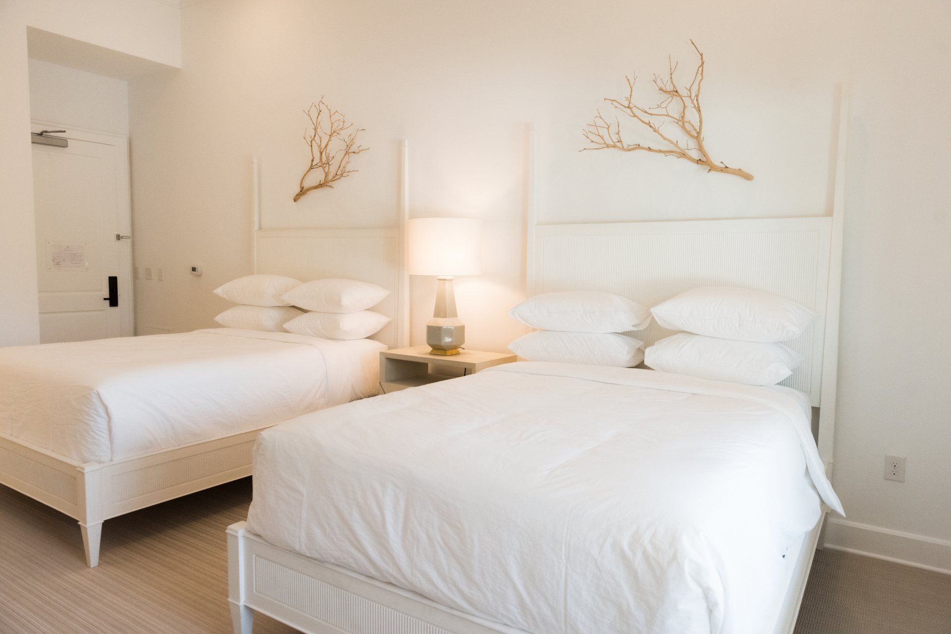 A hotel room with two beds and a lamp