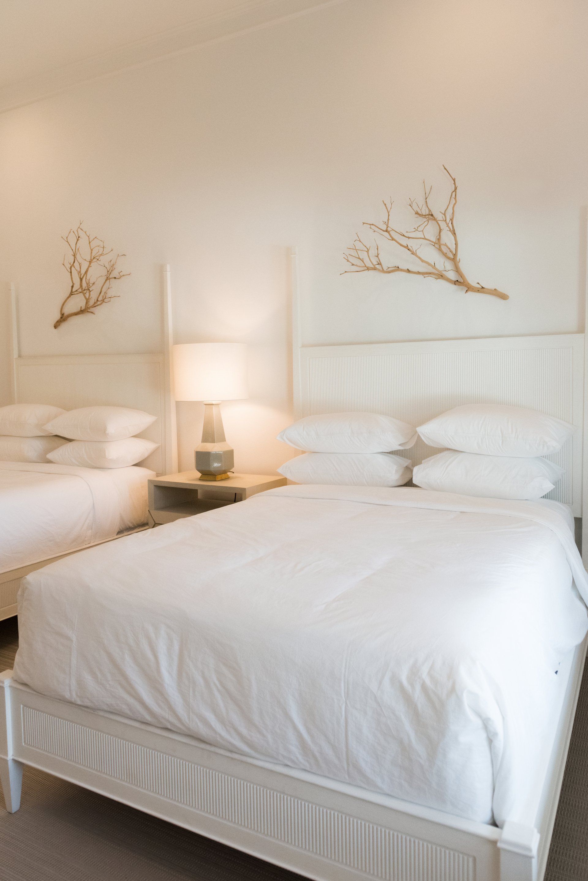A hotel room with two beds and a lamp