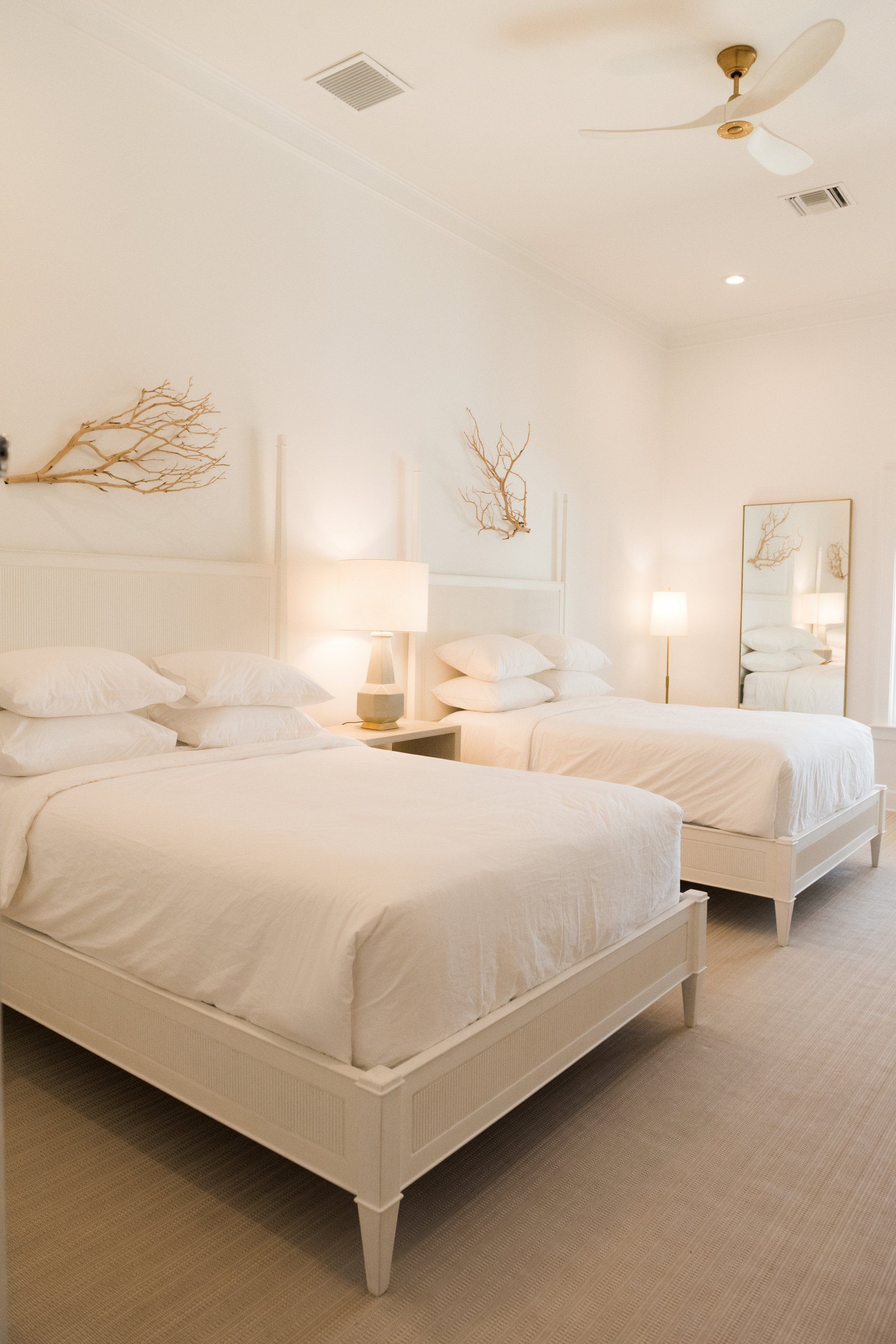 A bedroom with two beds and a ceiling fan