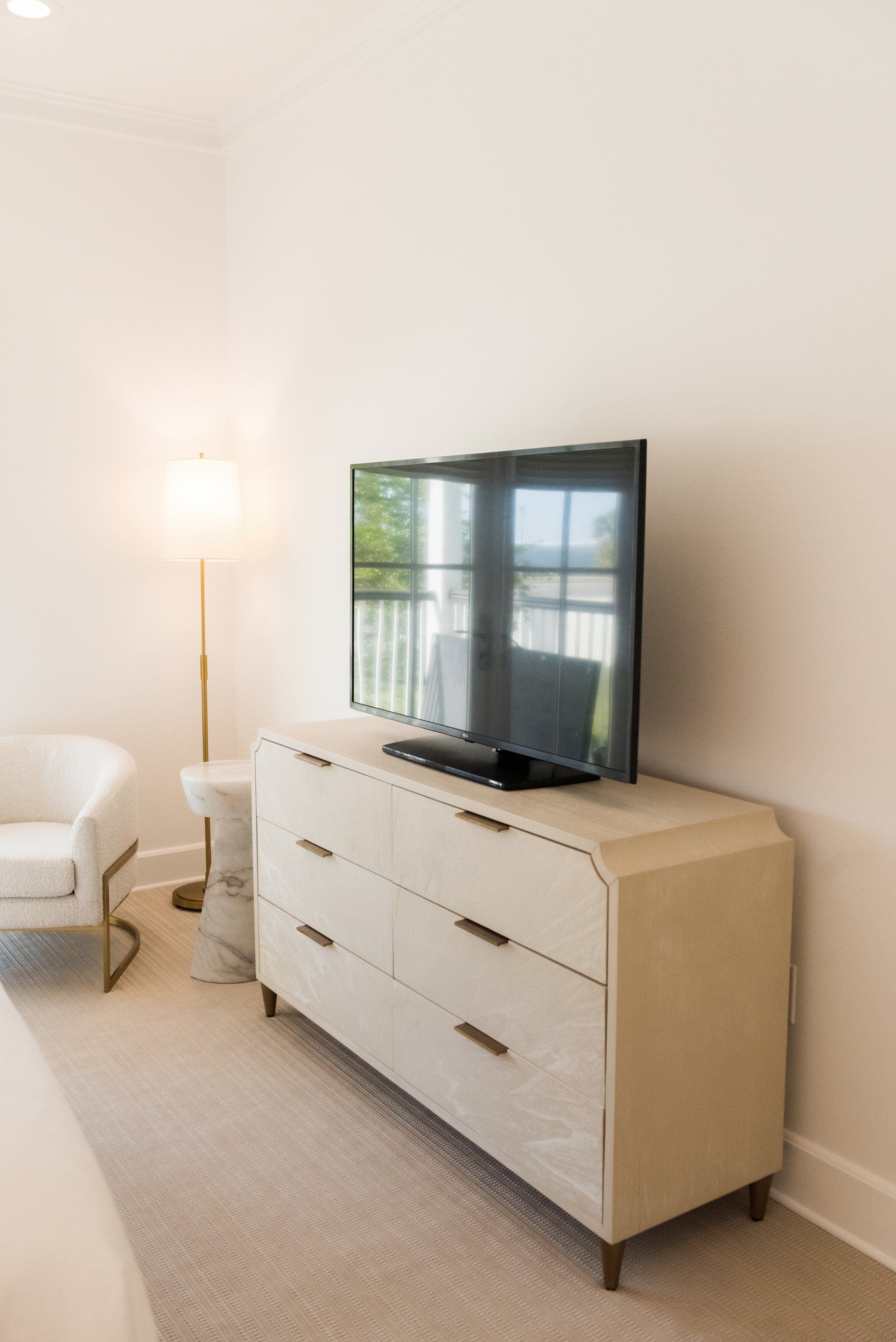 A bedroom with a dresser and a flat screen tv