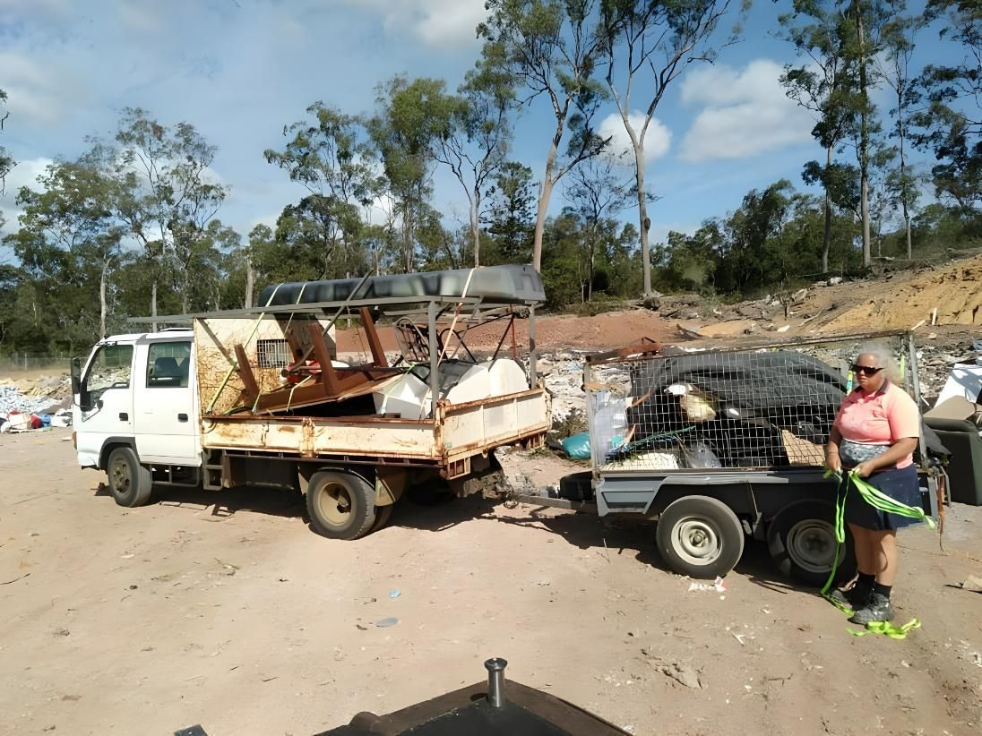 A Woman is Standing Next to a Truck That is Full of Trash — Handyman Bundaberg In Burnett Heads, QLD