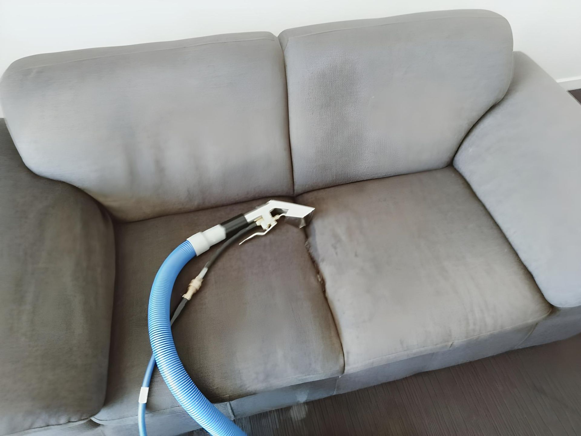 A Couch is Being Cleaned With a Vacuum Cleaner — Handyman Bundaberg In Burnett Heads, QLD