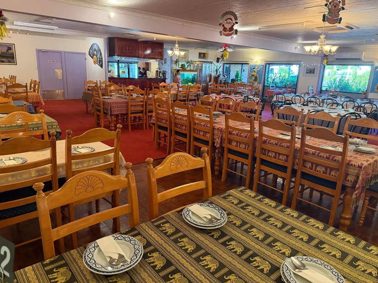 Dining Room With Round Tables, Red Carpet, and Wooden Chairs — Thai Taste Restaurant in Norman Gardens, QLD