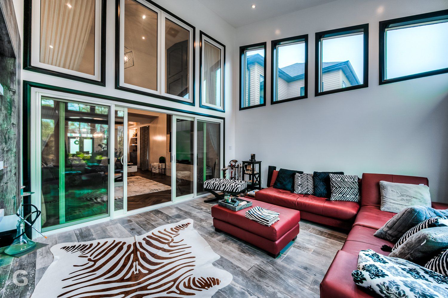 A living room with a red couch and a zebra rug