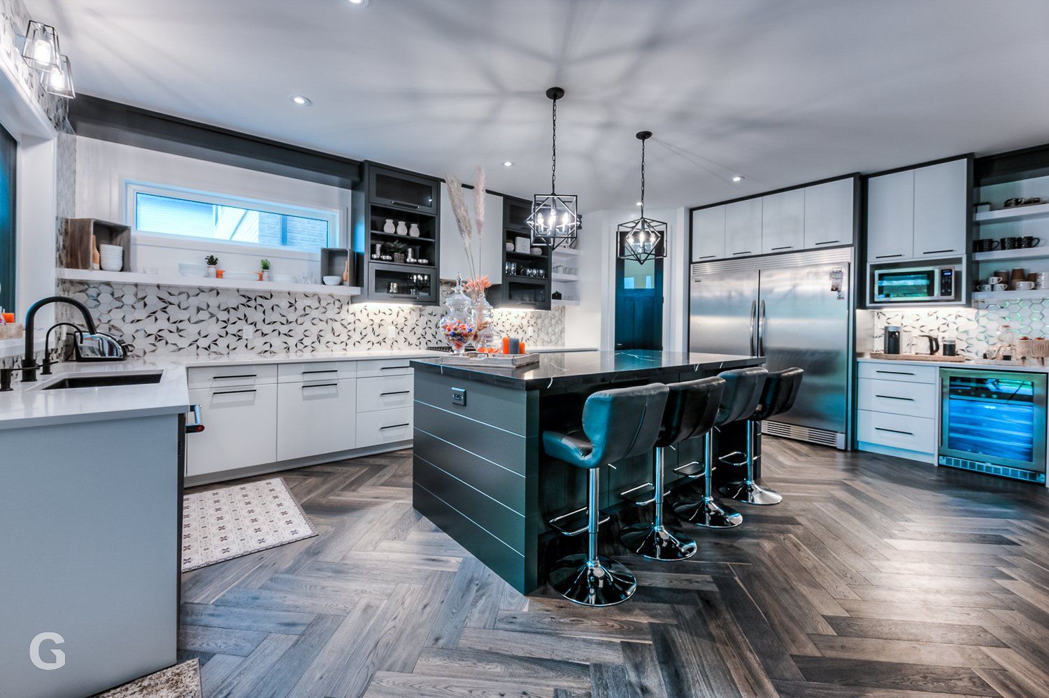 A large kitchen with stainless steel appliances and a large island in the middle.