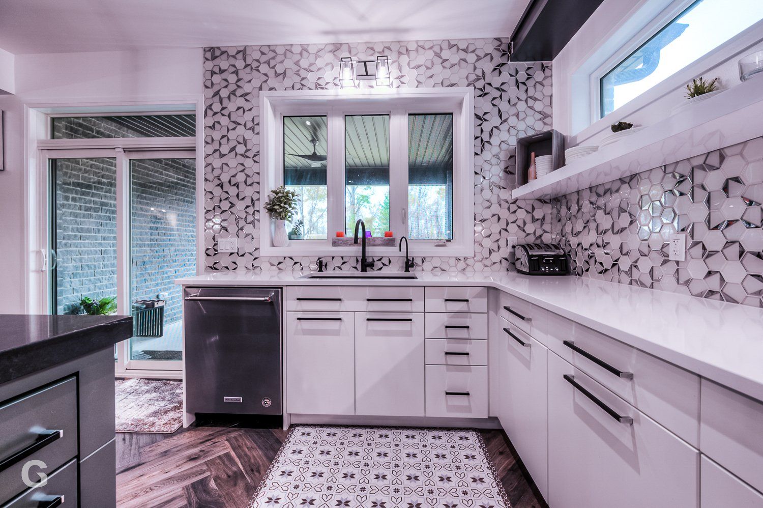 A kitchen with white cabinets and a black dishwasher.