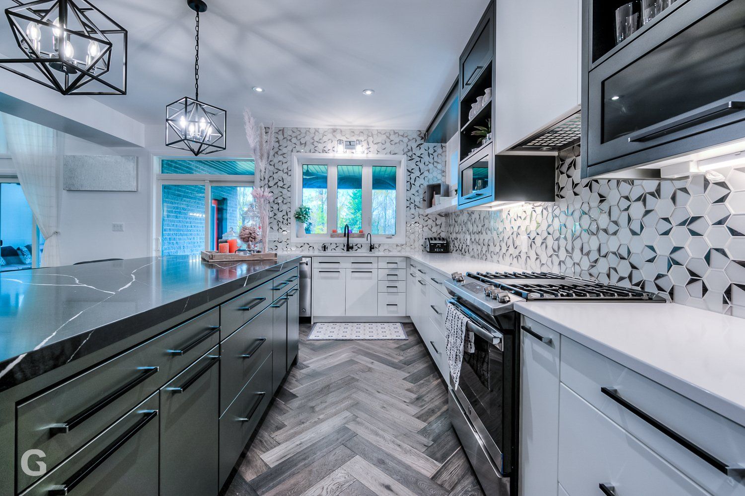 A kitchen with stainless steel appliances , white cabinets , and a herringbone floor.