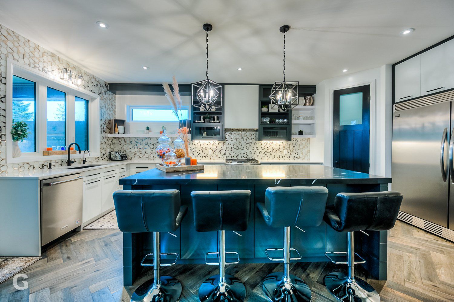 A kitchen with stools and a large island in the middle.