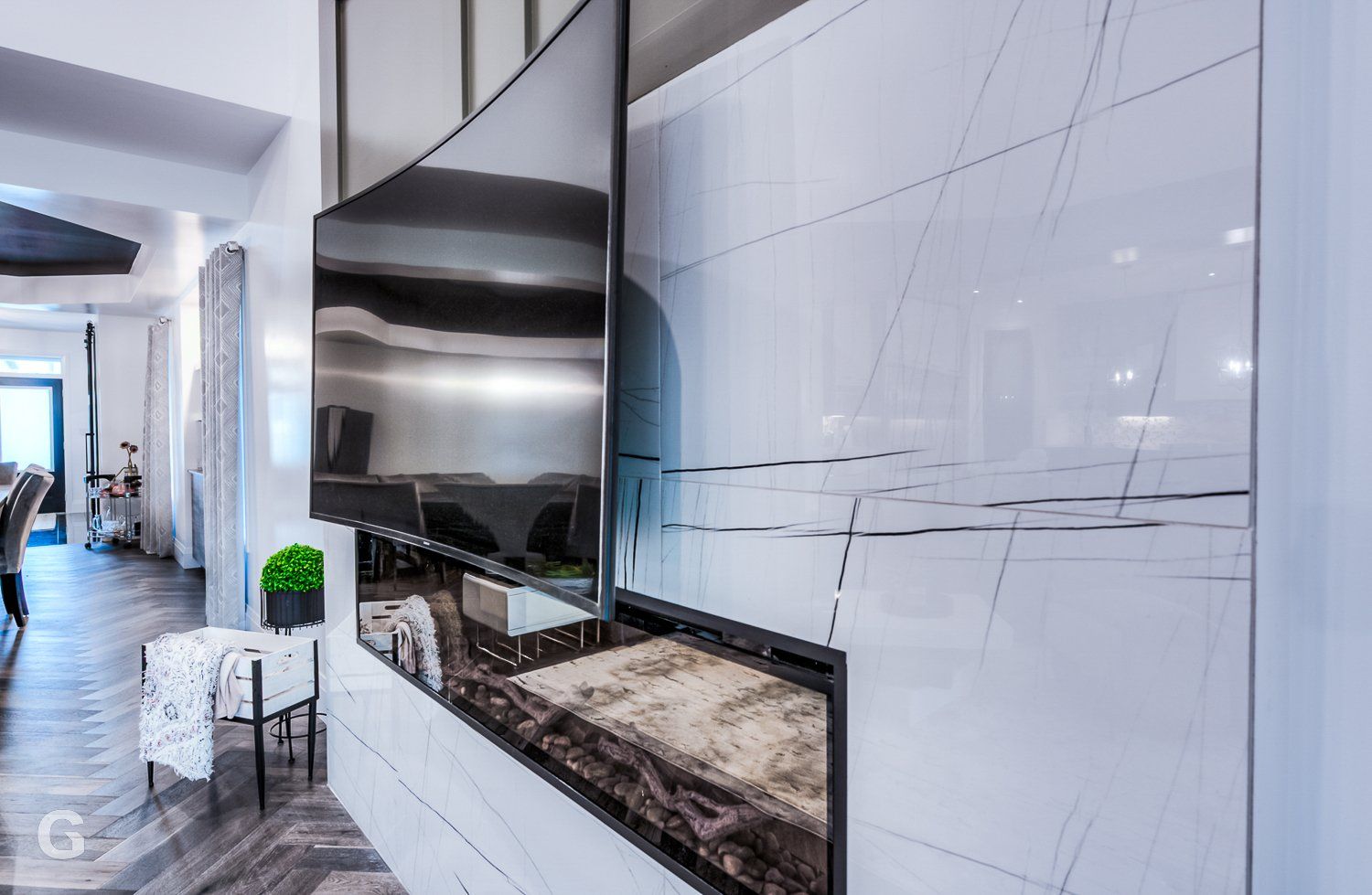 A living room with a fireplace and a flat screen tv on the wall.