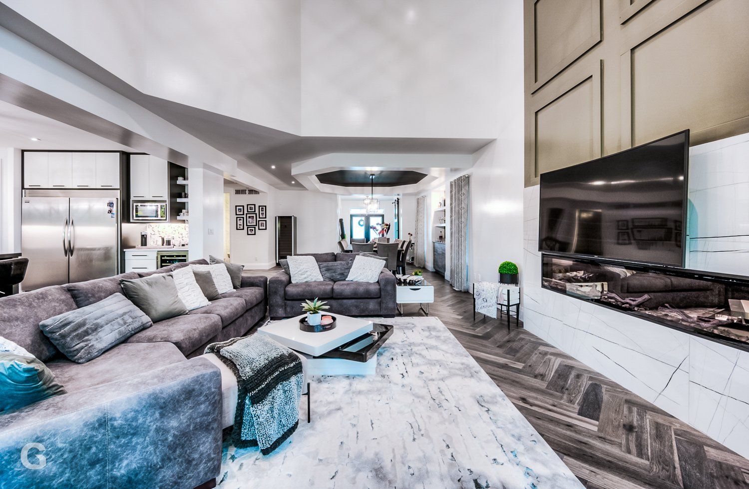 A living room with a large sectional couch and a flat screen tv.