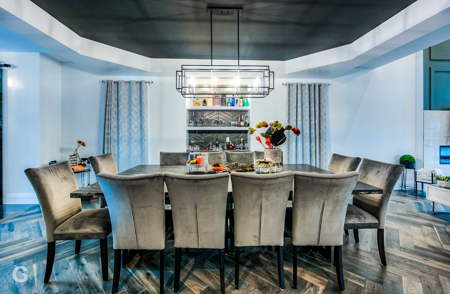 A dining room with a long table and chairs and a chandelier.