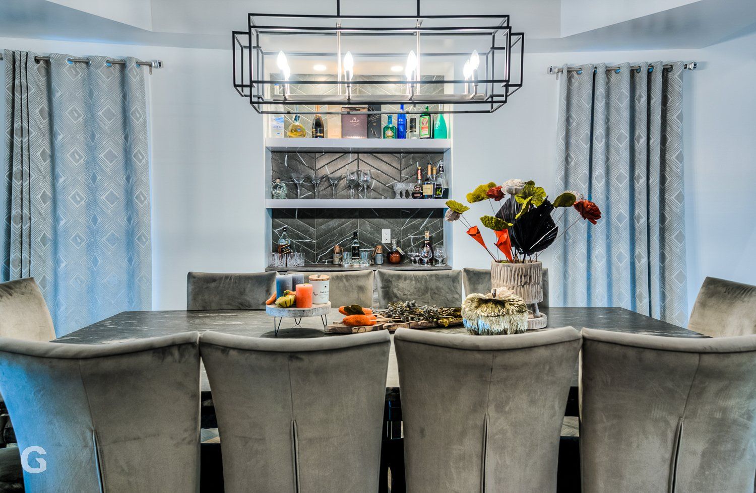 A dining room with a table and chairs and a chandelier.