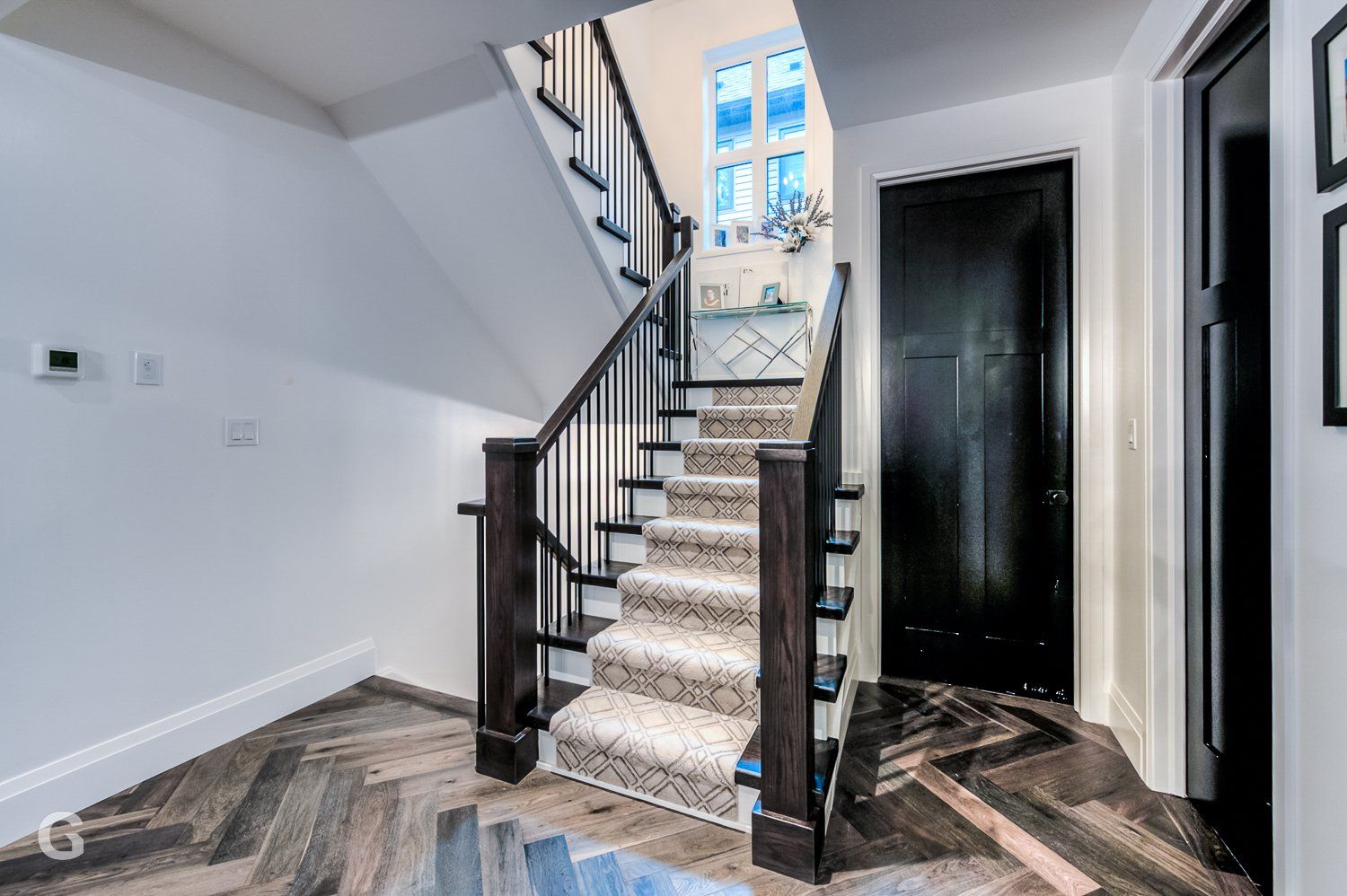 A staircase with a carpeted staircase leading up to the second floor of a house.
