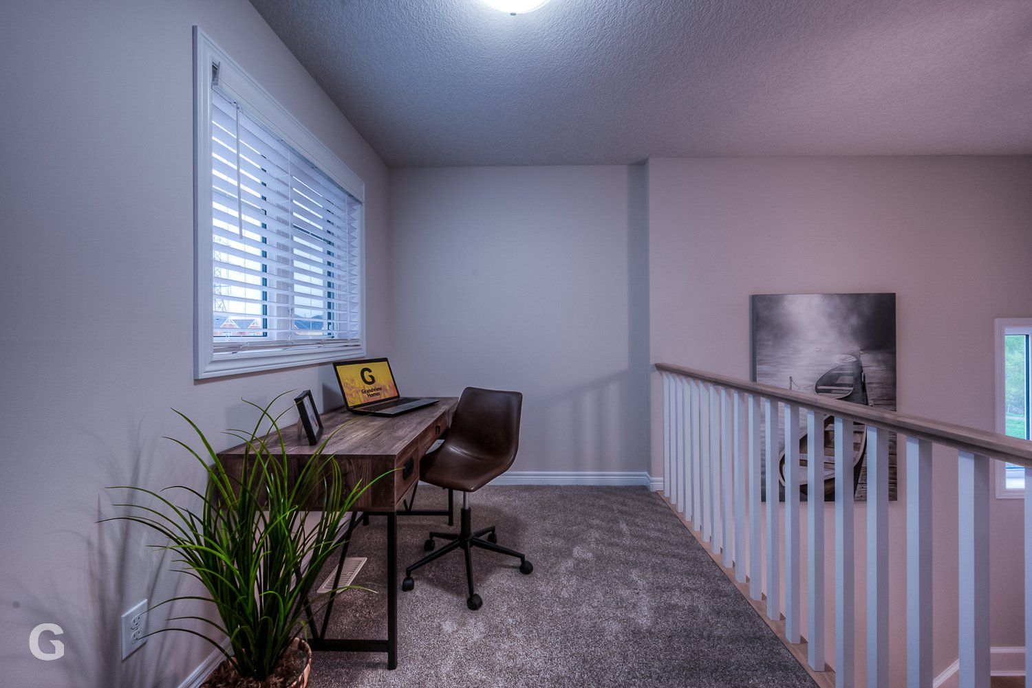 A room with a desk and chair and a laptop on it.