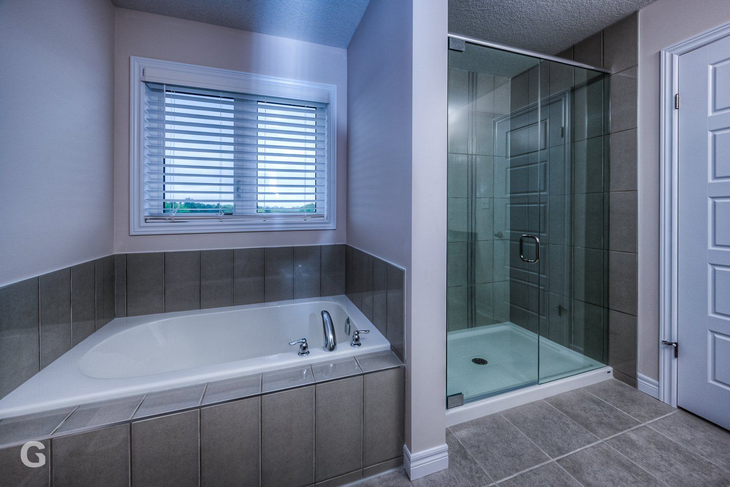 A bathroom with a tub and a walk in shower.