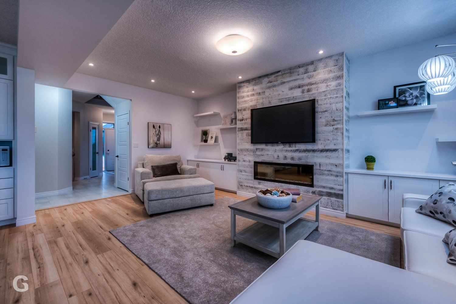 A living room with a fireplace and a flat screen tv on the wall.