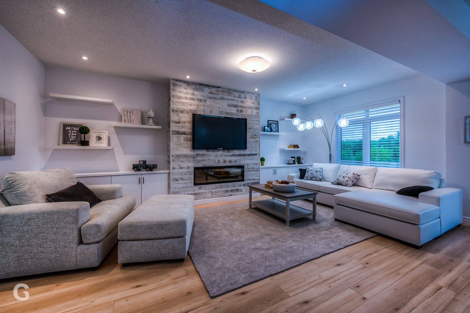 A living room with a couch , chair , coffee table and television.