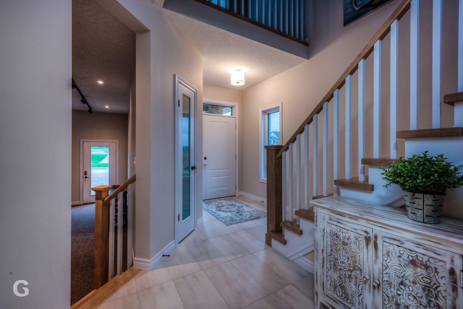 A hallway with stairs leading up to the second floor of a house.