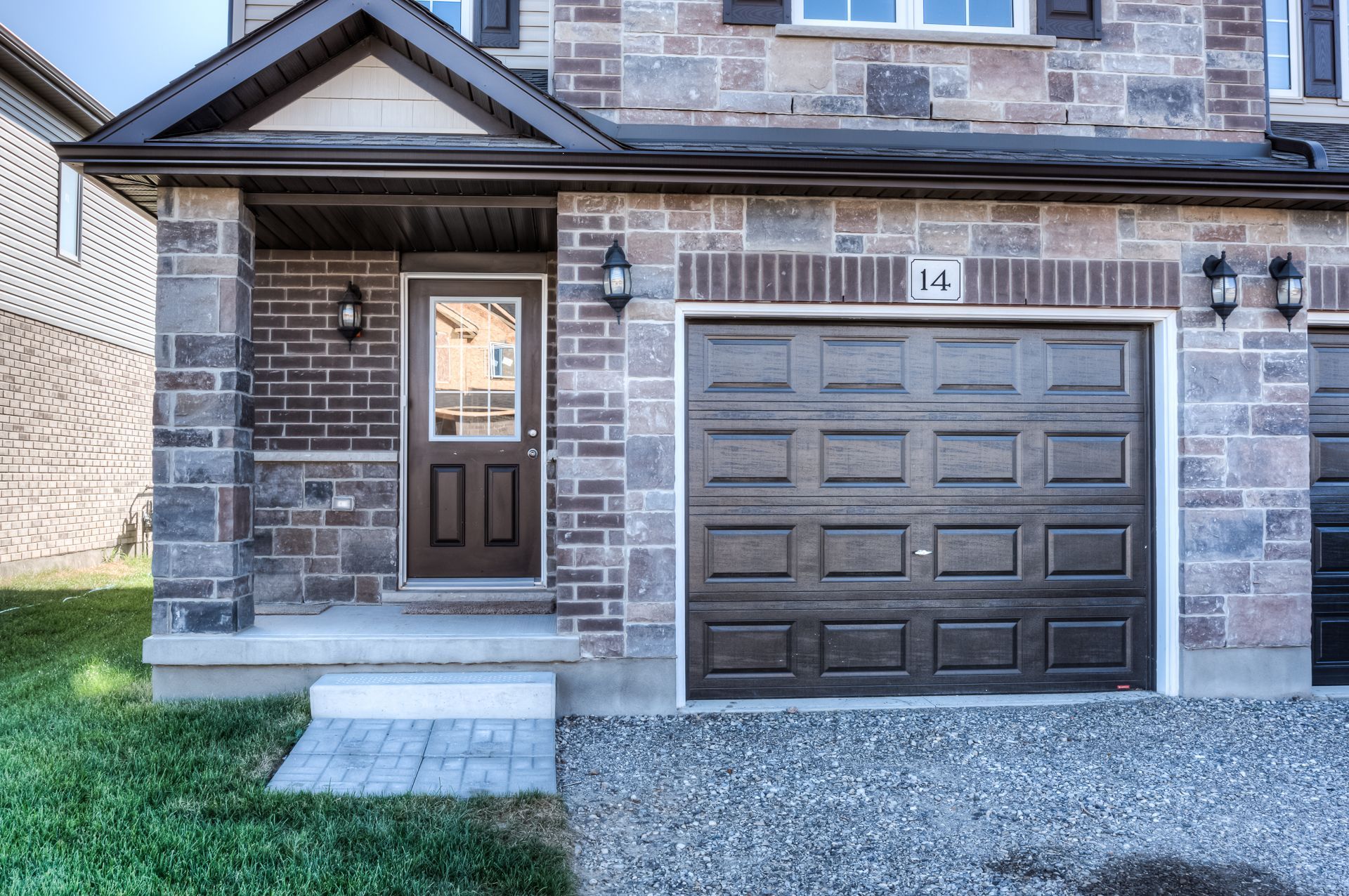 The front of a brick house with a brown garage door