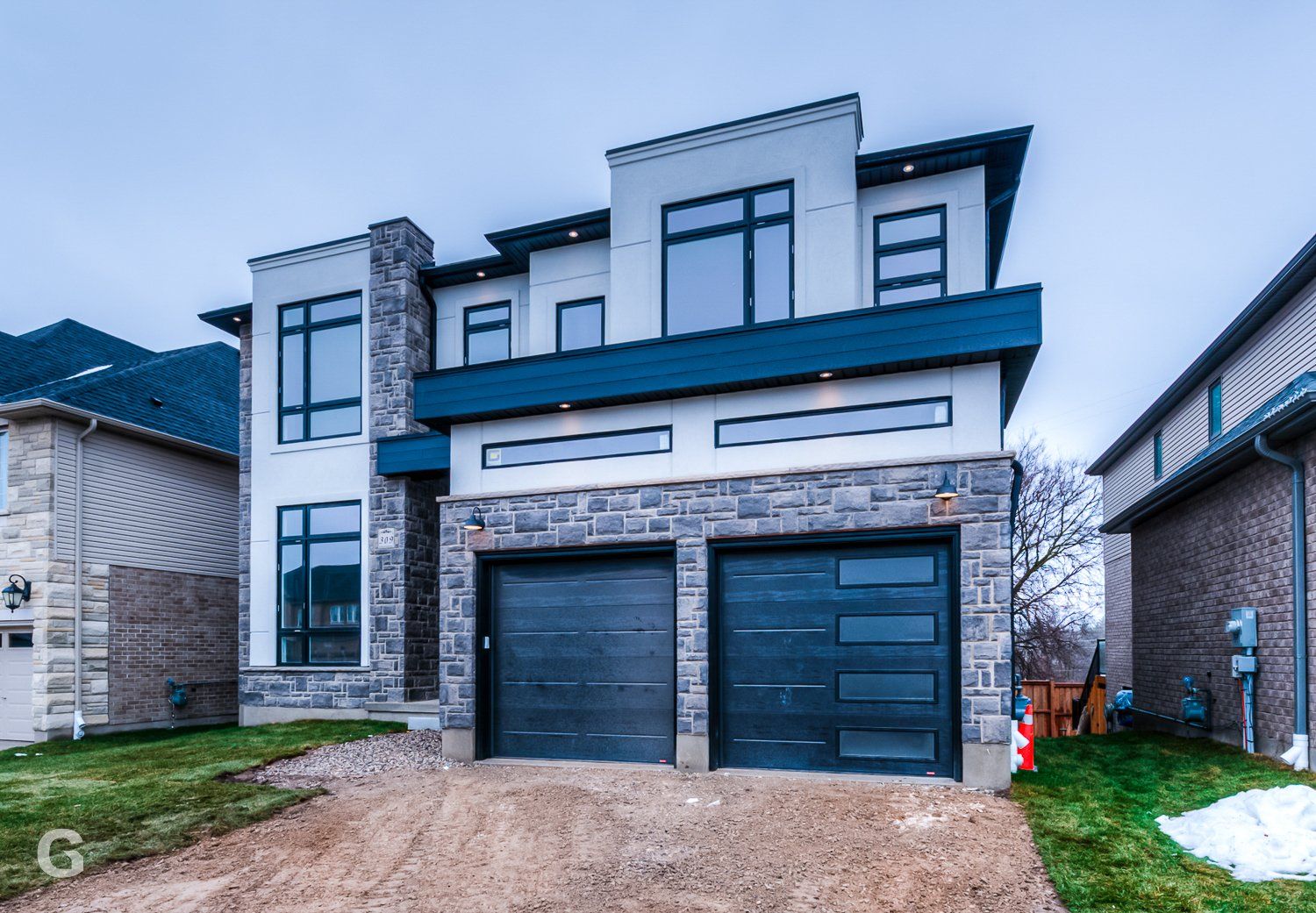 A large house with two garage doors and a lot of windows