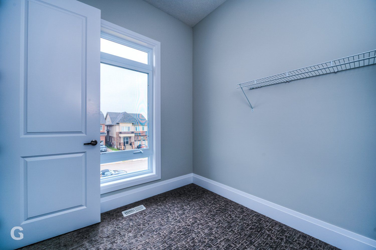 An empty room with a window and a white door.