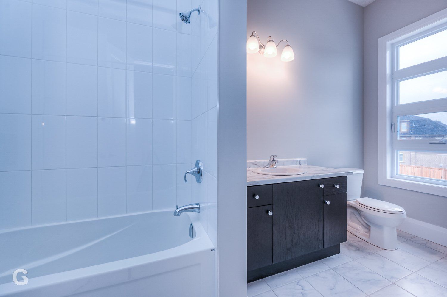 A bathroom with a tub , toilet , sink and shower.