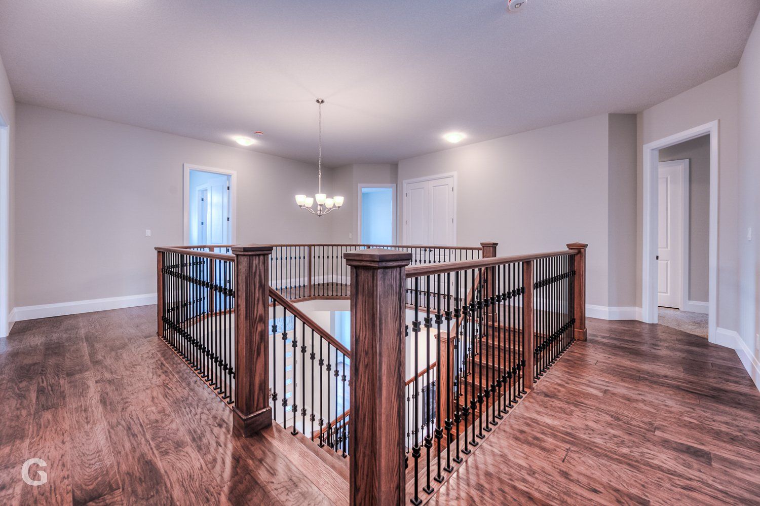 There is a staircase in the middle of the room with a wooden railing.