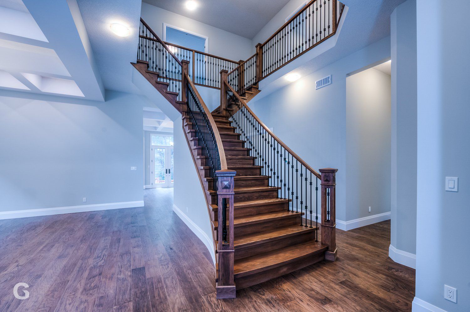 A wooden staircase with a metal railing in an empty house