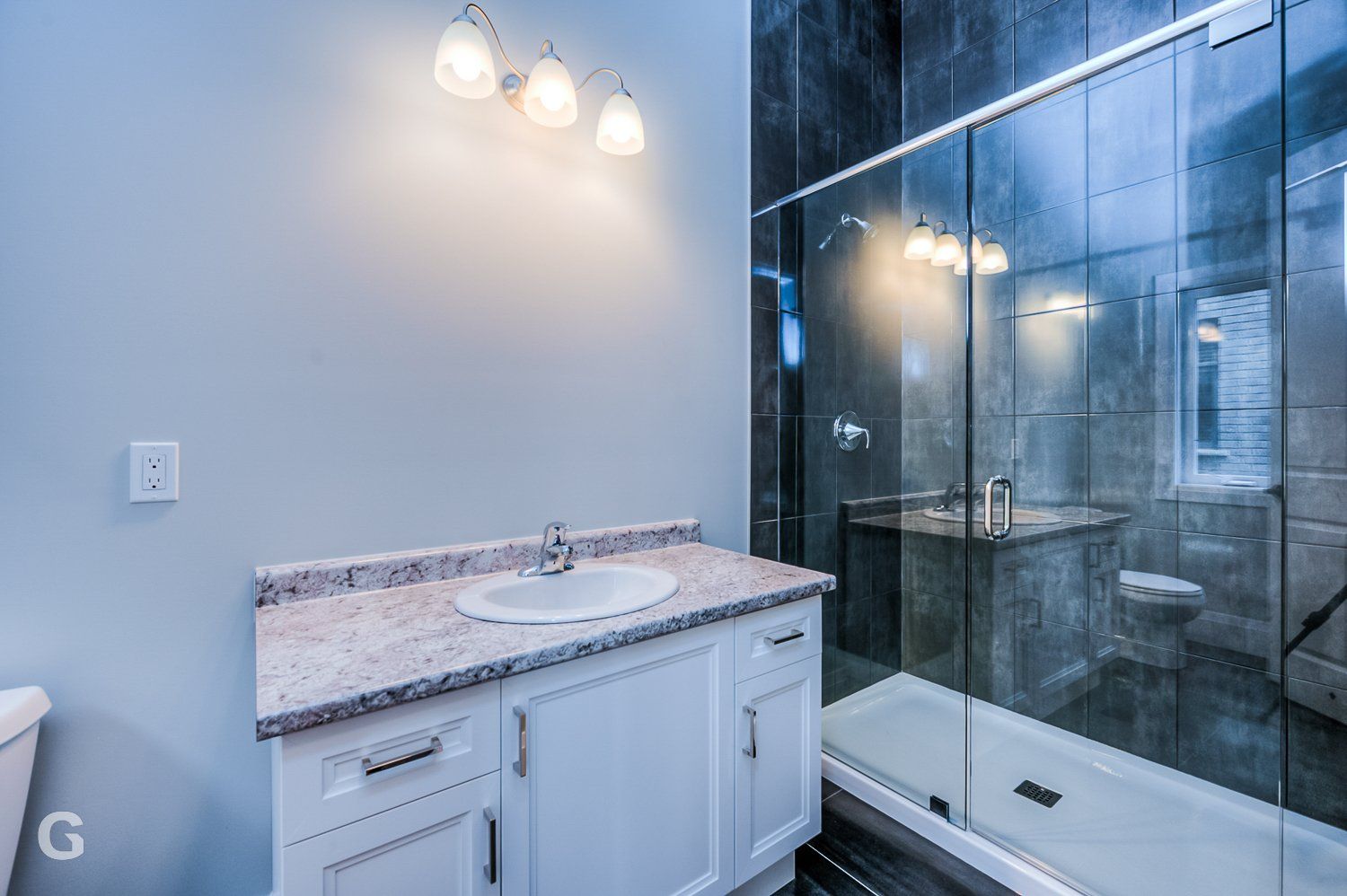 A bathroom with a sink , toilet and shower.