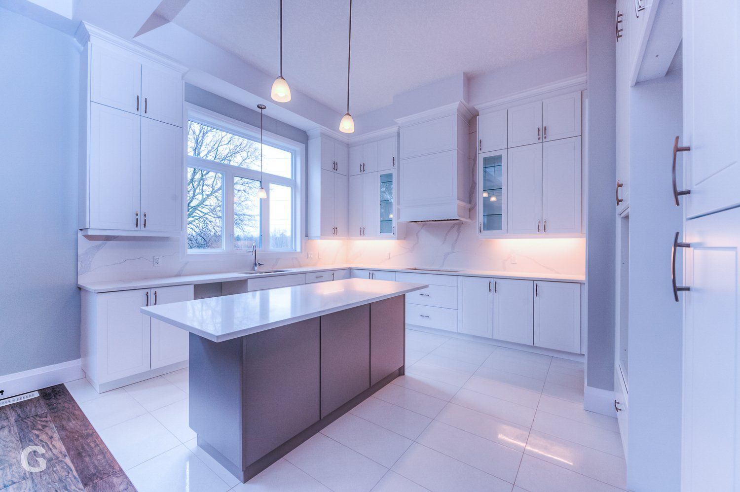 A kitchen with white cabinets and a large island in the middle.