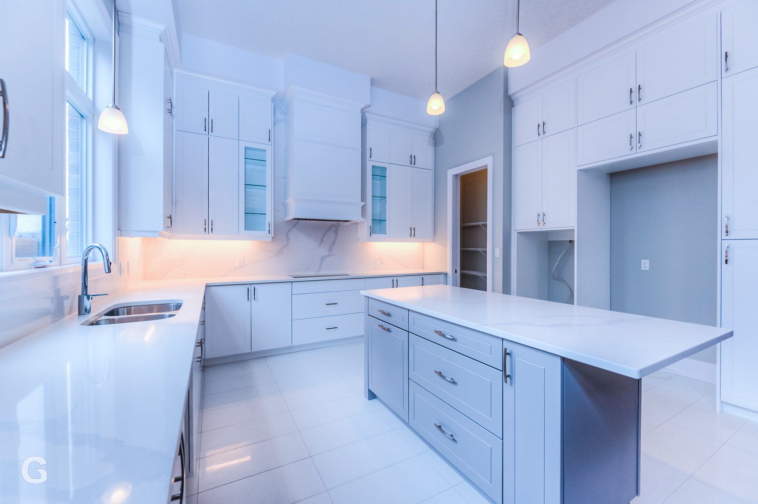 A kitchen with white cabinets and a large island in the middle.