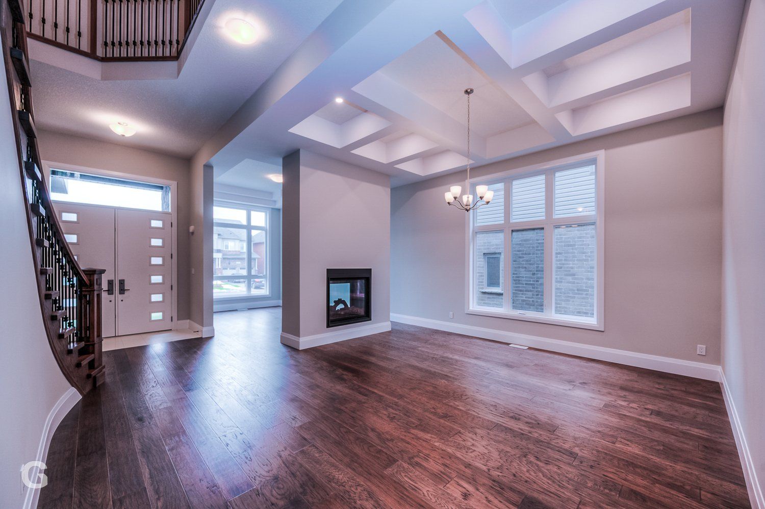 An empty living room with hardwood floors and a fireplace.