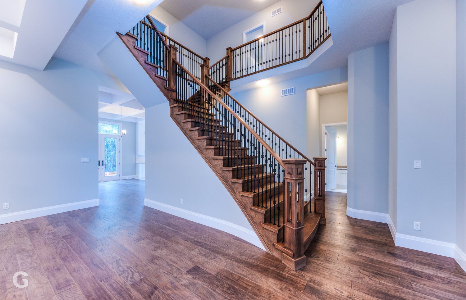 An empty house with a wooden staircase leading up to the second floor.