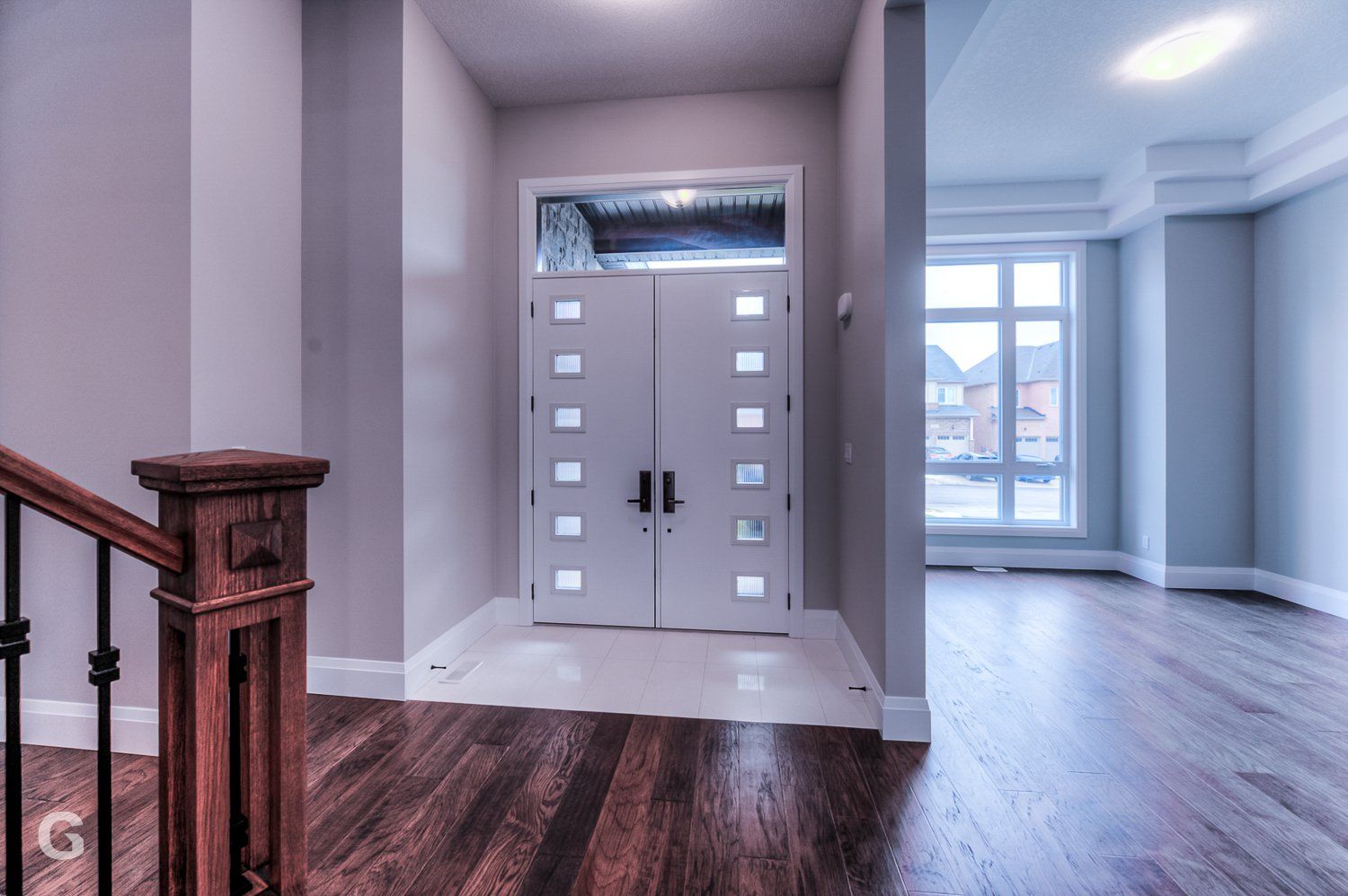 A hallway with a wooden staircase and a white door